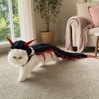 White Persian cat wearing black and red centipede cat costume